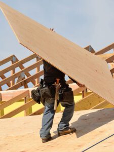 man-with-ply-board-on-roof